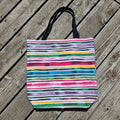Colorful striped tote bag on a wooden surface