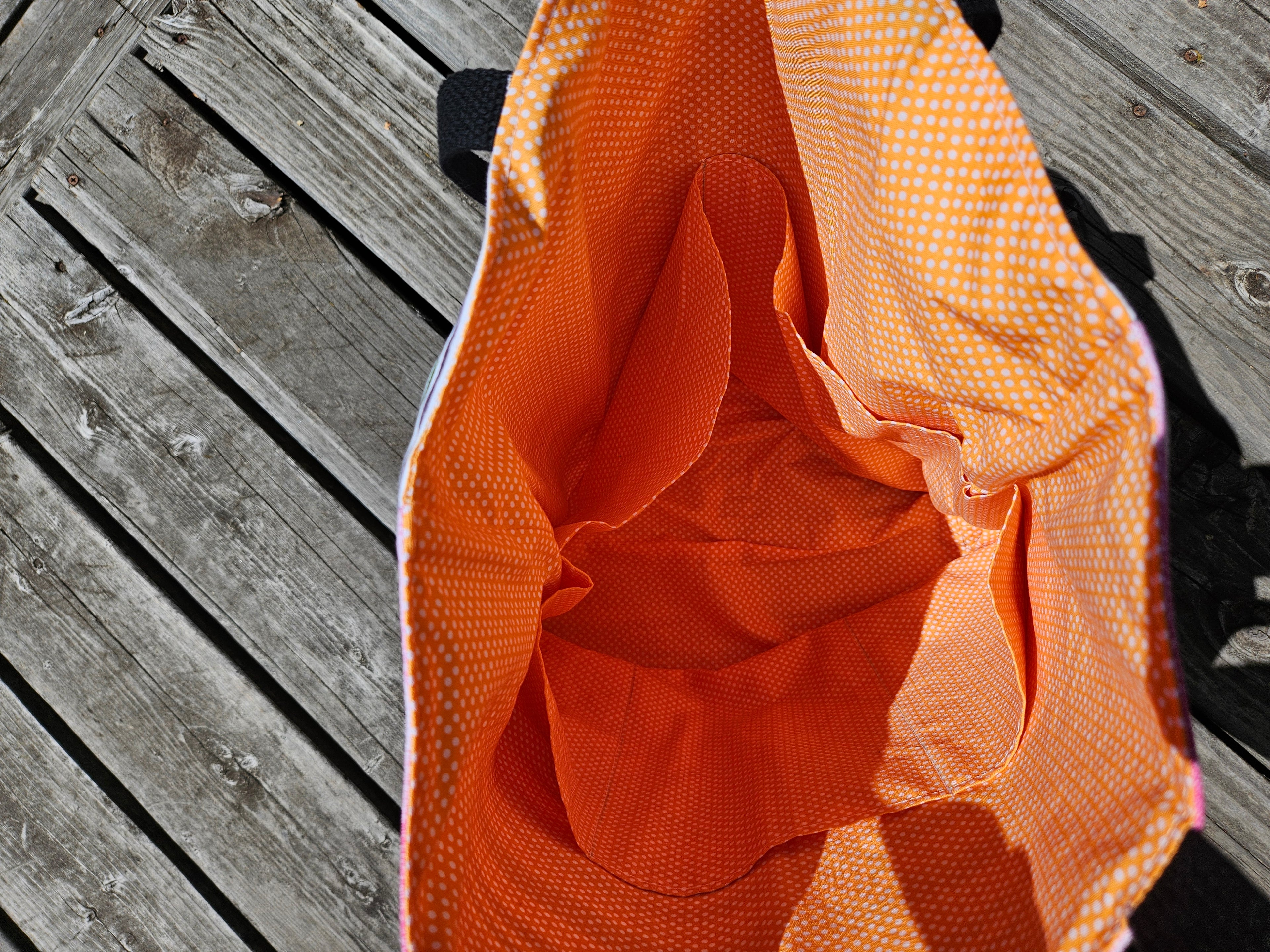 Close-up of interior orange tote bag on a wooden surface